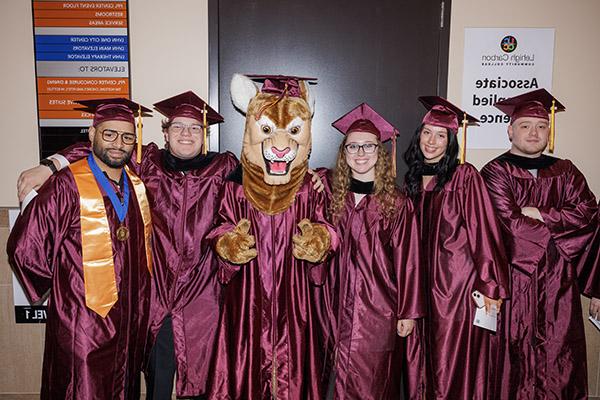 Students at graduation with LCCC mascot clawrence